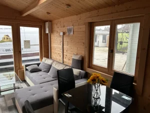 Bright dining space with timber walls and surrounding windows